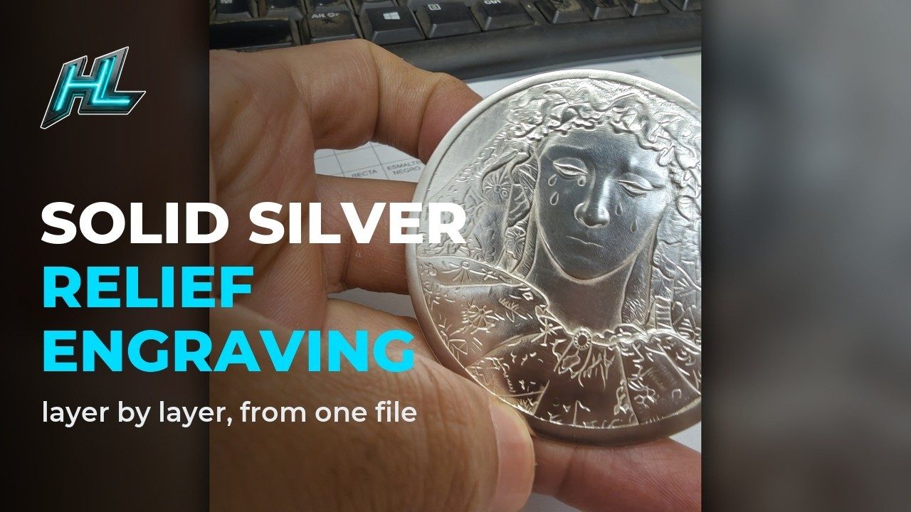 Solid silver medal engraved in deep relief with HagoLaser, held in a hand